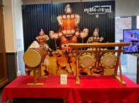川越まつり会館に展示されたお囃子の太鼓と山車の写真パネル