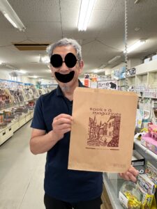 文林堂書店で使用されているクラフト紙の紙袋を持つ店主